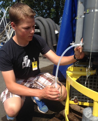 University Prep student Jacob Richey fills a sample bottle during a summer training session.